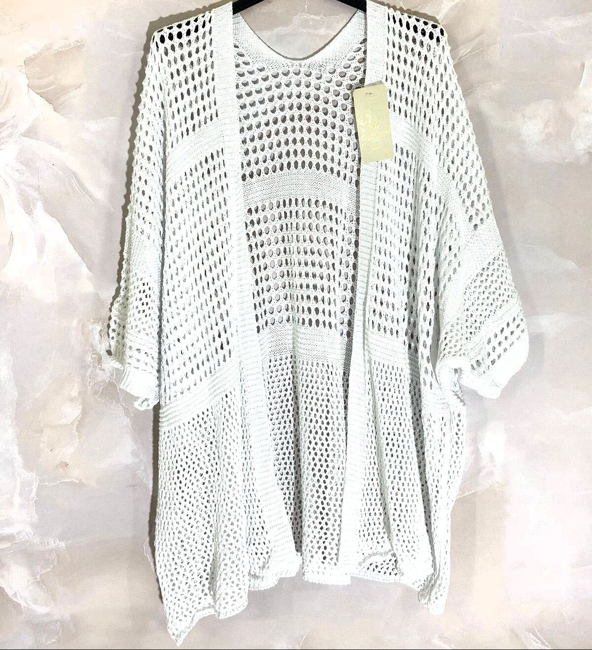 Loose-fitting cardigan with 3/4 sleeves, button closure, and enveloping comfort